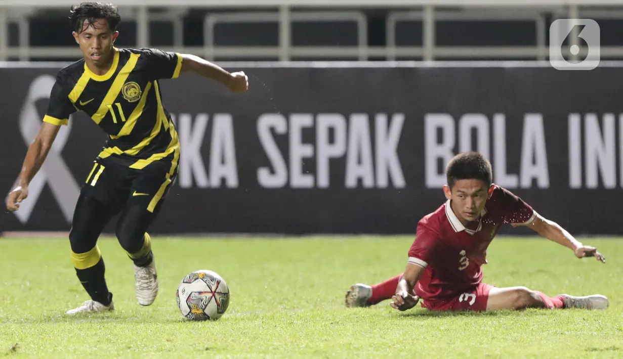 Pemain Timnas U-17 Indonesia, Irvansyah Arvanda Hermanto (kanan) gagal menahan pergerakan M Adam Mikaeel (Malaysia U-17) pada laga terakhir Kualifikasi Grup B Piala Asia U-17 2023 di Stadion Pakansari, Kab. Bogor, Jawa Barat, Minggu (9/10/2022). Laga kedua tim berlangsung sengit dan Timnas U-17 Indonesia menelan pil pahit kekalahan dari Malaysia U-17 dengan skor 1-5. (Liputan6.com/Helmi Fithriansyah)