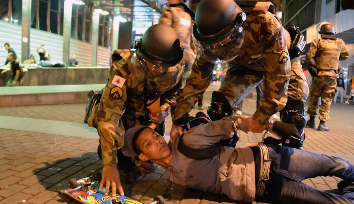 Salah satu demonstran terpaksa diamankan pihak kepolisian di Belo Horizonte, Brasil, (12/6/2014). (AFP PHOTO/Eitan Abramovich)