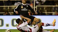 Pemain sayap Real Madrid Cristiano Ronaldo dilanggar pemain Rayo Vallecano Antonio Amaya (JAVIER SORIANO/AFP)