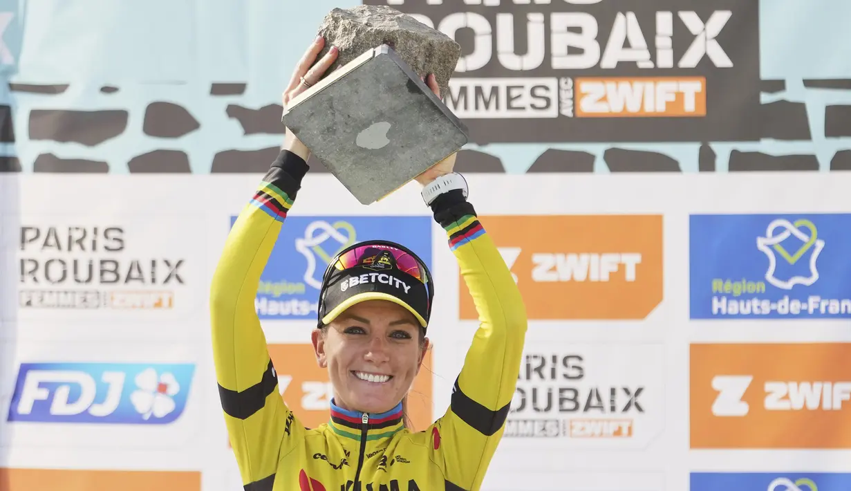 Pembalap Team Visma-Lease, Pauline Ferrand-Prevot menjunjung trofi kemenangan Paris Roubaix Femmes 2025 pada Sabtu (12/04/2025) waktu setempat. Perlombaan tersebut menempuh 148,5 km dari Denain hingga Roubaix, Prancis. (AP Photo/Thibault Camus)
