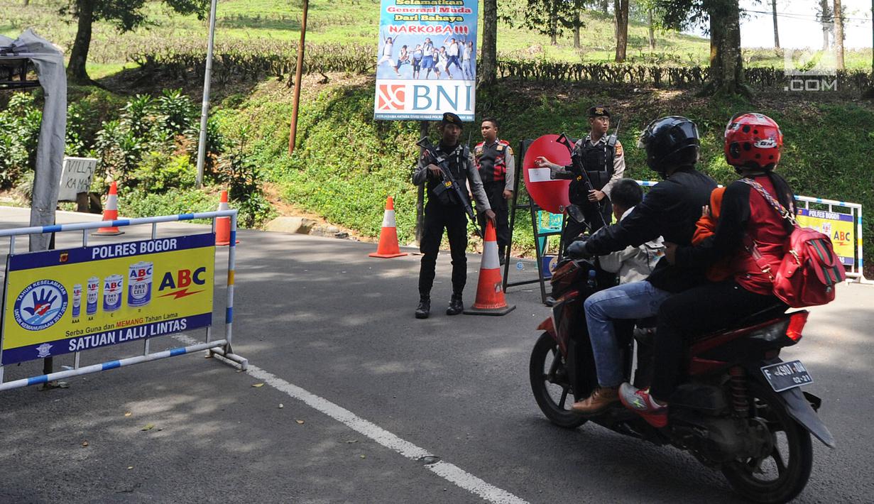 Pengendara motor melawati jalan yan dijaga polisi di di kawasan Puncak, Bogor (29/03). Akibat terjadi longsor di Ciloto, sejumlah jalan di kawasan puncak ditutup. (Merdeka.com/Arie Basuki)