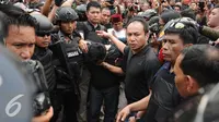 Petugas kepolisian menggiring salah satu tersangka perampokan disertai penyanderaan di Kawasan Pondok Indah, Jakarta, Minggu (3/9). Perampokan disertai penyanderaan terjadi sejak Minggu (3/9) pagi. (Liputan6.com/Helmi Fithriansyah)