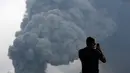 Seorang wisatawan mengabadikan gambar semburan abu vulkanik dari Gunung Bromo yang sedang erupsi di Ngadisari, Probolinggo, Jawa Timur, Selasa (5/1/2016). (REUTERS/Darren Whiteside)