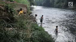 Sejumlah anak bermain di Sungai Ciliwung, Depok, Jawa Barat, Kamis (4/7/2019). Menurunnya debit air Sungai Ciliwung akibat musim kemarau dimanfaatkan warga setempat sebagai tempat wisata gratis untuk mengajak anak berenang. (merdeka.com/Iqbal Nugroho)
