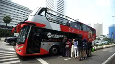 Warga antre untuk menaiki bus tingkat Transjakarta dengan atap terbuka di Jakarta, Selasa (10/5/2022). Selama libur Lebaran, bus wisata tersebut melayani warga menuju berbagai rute destinasi wisata Ibu Kota. (merdeka.com/Imam Buhori)