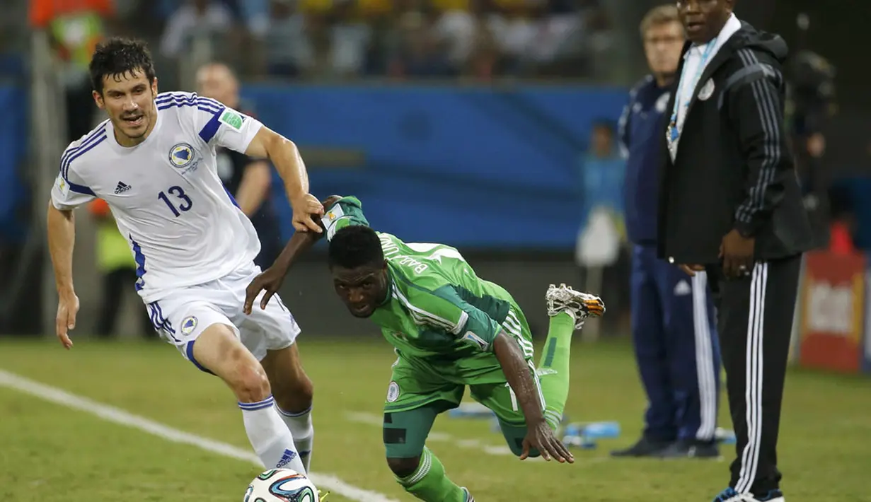 Pemain belakang Bosnia, Mensur Mujdza (kiri) mencoba menahan pergerakan gelandang Ghana, Michael Babatunde, saat berlaga di penyisihan Piala Dunia 2014 Grup F di Stadion Pantanal, Cuiaba, Brasil, (22/6/2014). (REUTERS/Eric Gaillard)