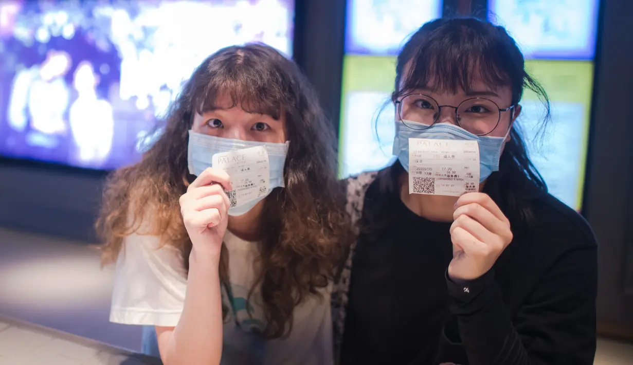 Pengunjung menunjukkan tiket mereka di sebuah bioskop di Wuhan, Provinsi Hubei, China, Senin (20/7/2020). Dengan mengambil berbagai langkah pencegahan COVID-19, bioskop-bioskop di Kota Wuhan mulai kembali dibuka secara bertahap pada 20 Juli 2020. (Xinhua/Xiao Yijiu)