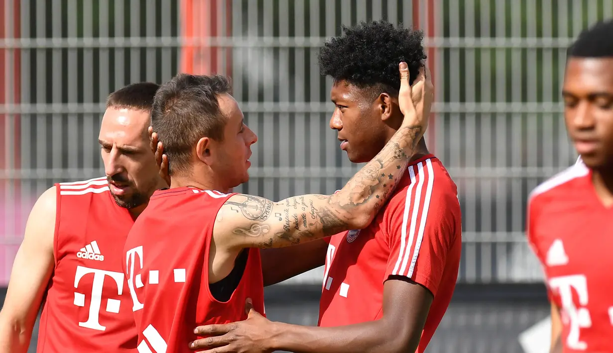 Gelandang Bayern Munchen, Rafinha, tampak berbincang santai dengan David Alaba saat latihan perdana di Munchen, Rabu (12/7/2017). (EPA/Lukas Barth)