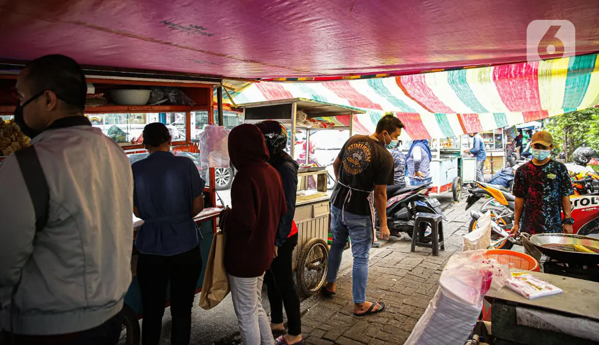 Pedagang melayani pembeli di Pasar Takjil Benhil, Jakarta, Selasa (13/4/2021). Pasar takjil yang ada setiap bulan Ramadhan tersebut dipadati warga untuk membeli makanan berbuka puasa. (Liputan6.com/Faizal Fanani)