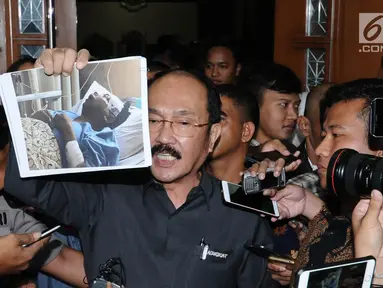 Mantan kuasa hukum terdakwa dugaan korupsi pengadaan e-KTP Setya Novanto, Fredrich Yunadi menunjukkan foto kliennya saat berada di rumah sakit usai menjalani sidang di Pengadilan Tipikor, Jakarta, Kamis (8/2). (Liputan6.com/Helmi Fithriansyah)