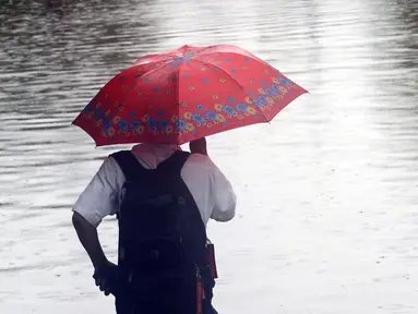 Warga melihat Jalan Di Panjaitan dekat Halte Transjakarta Cawang Soetoyo yang tergenang banjir, Jakarta, Rabu (1/1/2020). Hujan yang mengguyur Jakarta sejak Selasa sore (31/12/2019) mengakibatkan banjir di sejumlah titik di Jakarta. (Liputan6.com/Helmi Fithriansyah)