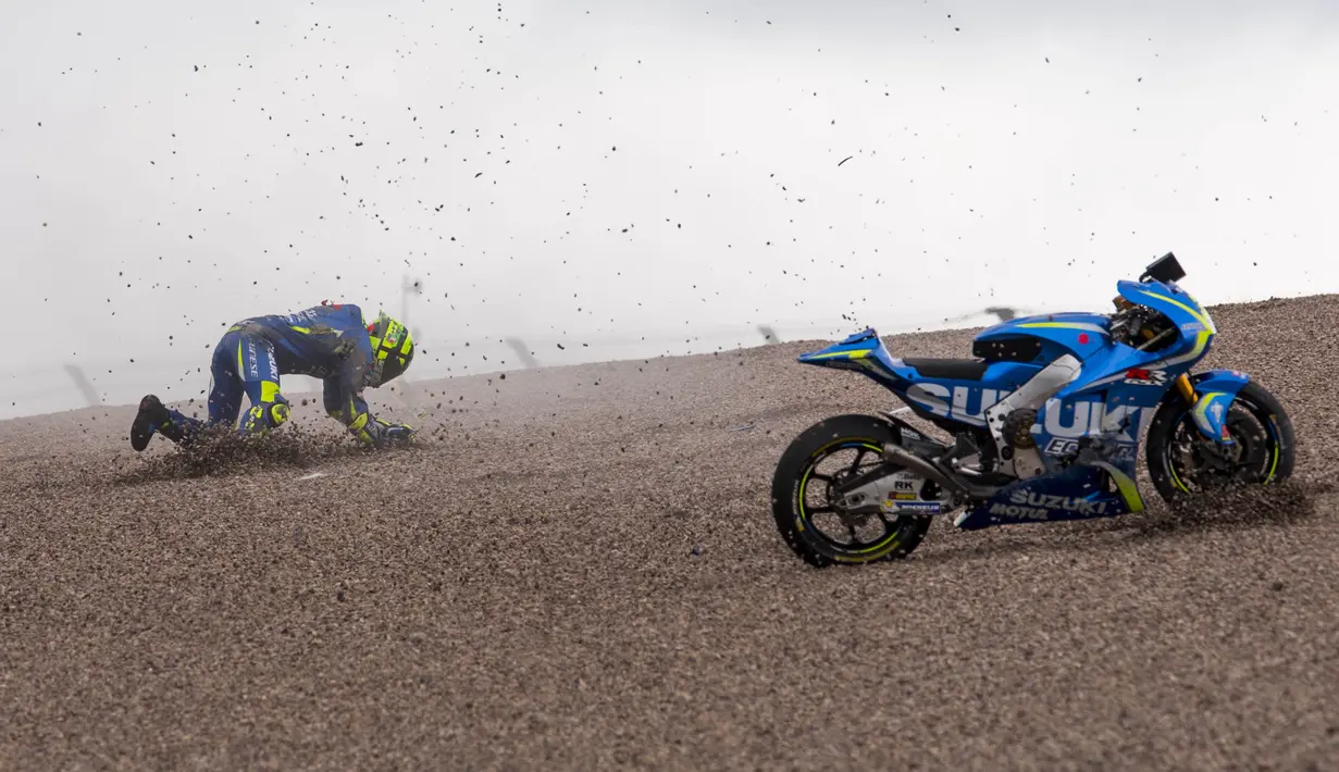 Pebalap Suzuki Ecstar, Andrea Iannone, berusaha kembali ke motor setelah terjatuh saat menjalani latihan bebas MotoGP Jerman di Sirkuit Sachsenring, Hohenstein-Ernstthal, Jumat (30/6/2017). (AFP/Robert Michael)