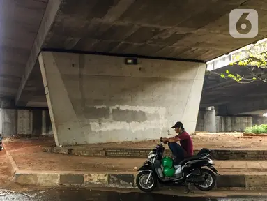 Pengendara motor beristirahat di jalur putar balik Jalan Gatot Soebroto, kawasan Kuningan, Jakarta, Selasa (12/11/2019). Jalur yang kini hanya bisa dilalui kendaraan roda dua itu menjadi lokasi sebagian pemotor beristirahat karena teduh tertutup jalan tol dalam kota. (Liputan6.com/Immanuel Antonius)