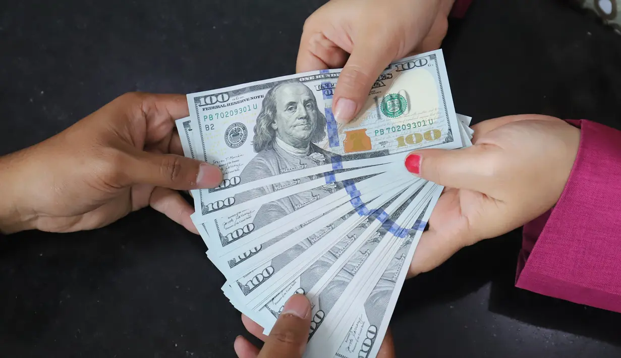 Karyawan menunjukkan lembaran uang Dolar AS di VIP Money Changer, Jakarta, Jumat (5/6/2026). (merdeka.com/Arie Basuki)