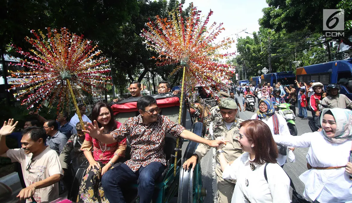 Gubernur DKI Jakarta Djarot Saiful Hidayat bersama istri Happy Farida menaiki delman sambil melambaikan tangan kepada warga dan pegawai Pemprov DKI Jakarta saat perpisahan dirinya di Balaikota DKI Jakarta, Minggu (15/10). (Liputan6.com/Immanuel Antonius)