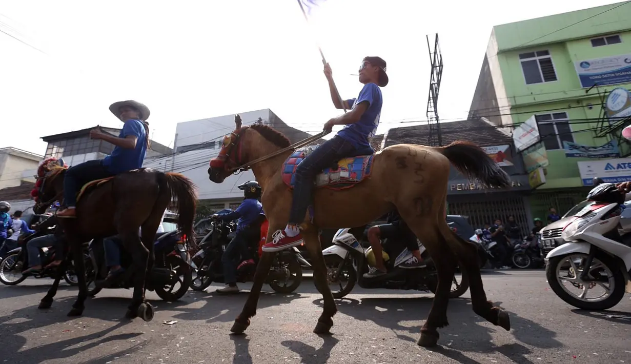 Suporter Persib berkuda mengiringi Pawai Persib Juara di jalanan kota Bandung, Minggu (25/10/2015). (Bola.com/Nicklas Hanoatubun)