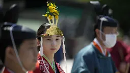 Seorang pendeta muda Shinto yang disebut "miko," tengah, dan pendeta Shinto mempersiapkan upacara upacara untuk festival dua tahunan yang disebut "Kanda Matsuri" di kuil Kanda (18/5/2022). (AP Photo/Eugene Hoshiko)