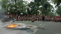 Massa aksi yang dipukul mundur ke Jalan Diponegoro arah Gedung Sate tetap bertahan. Aksi bakar ban di depan Gedung Sate Bandung sambil berorasi. (Liputan6.com/Huyogo Simbolon)