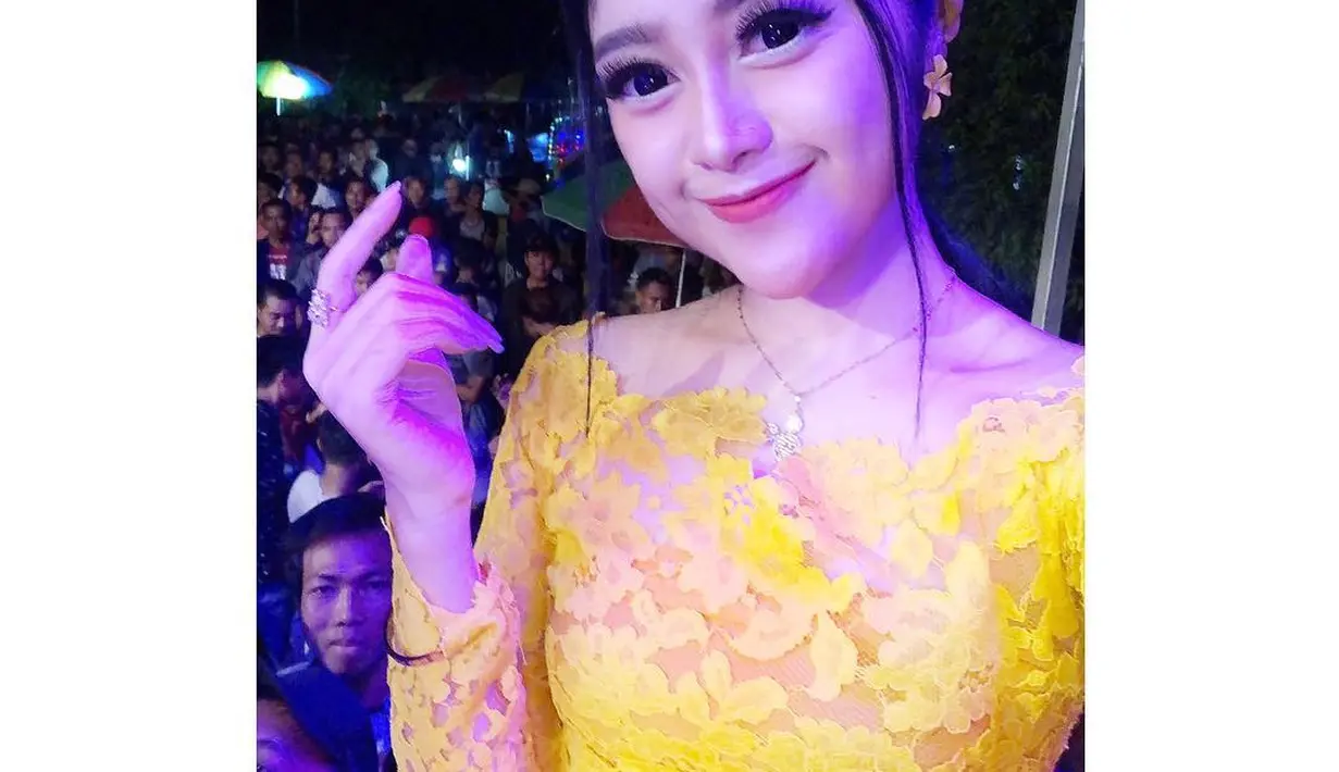 Saat tampil di atas panggung, Vivi Artika menggunakan dress brokat berwarna kuning. Terlihat sangat cerah dan cantik serta bando yang digunakan juga senda. (Liputan6.com/IG/@viviartika)
