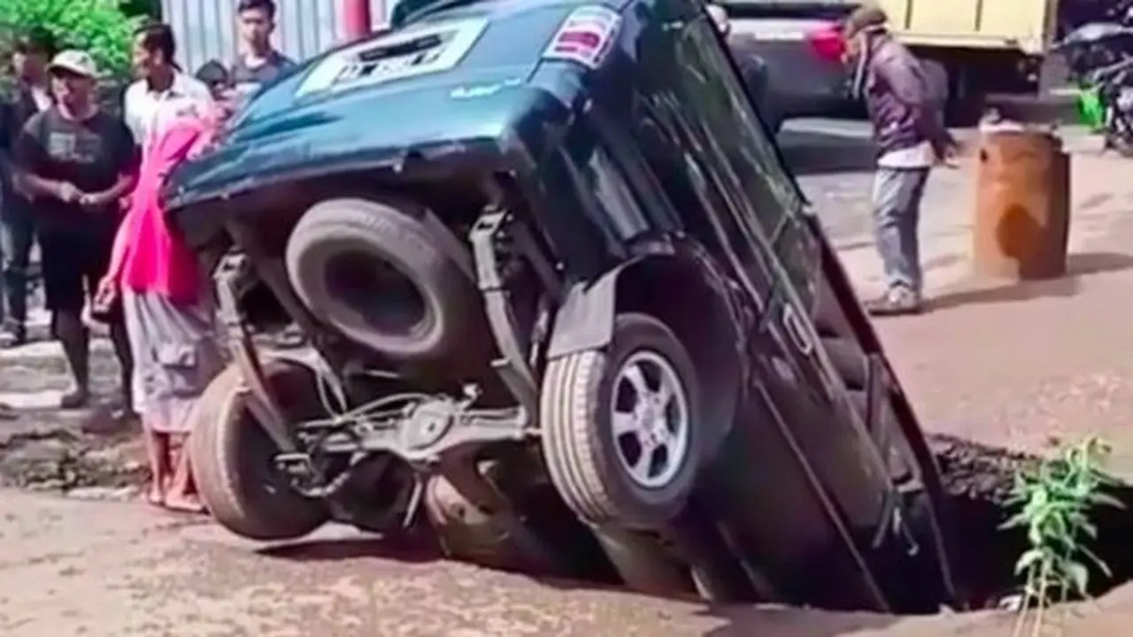 Toyota Kijang nyungsep di lubang jalan