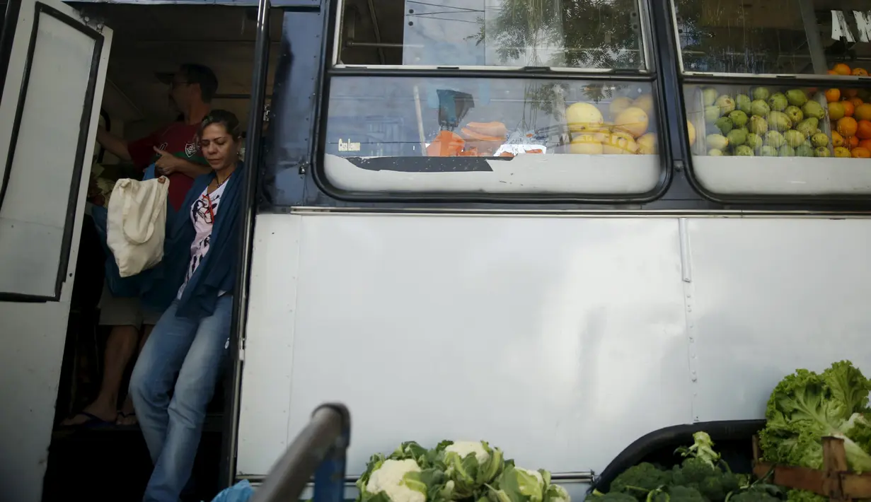 Warga usai berbelanja di dalam pasar bus 'Sacolao' di Santa Teresa di Rio de Janeiro, Brasil, Selasa (7/7/2015). Pasar bus ini memfasilitasi warga yang ingin berbelanja sayur dan buah-buahan dengan harga yang terjangkau. (REUTERS/Pilar Olivares)