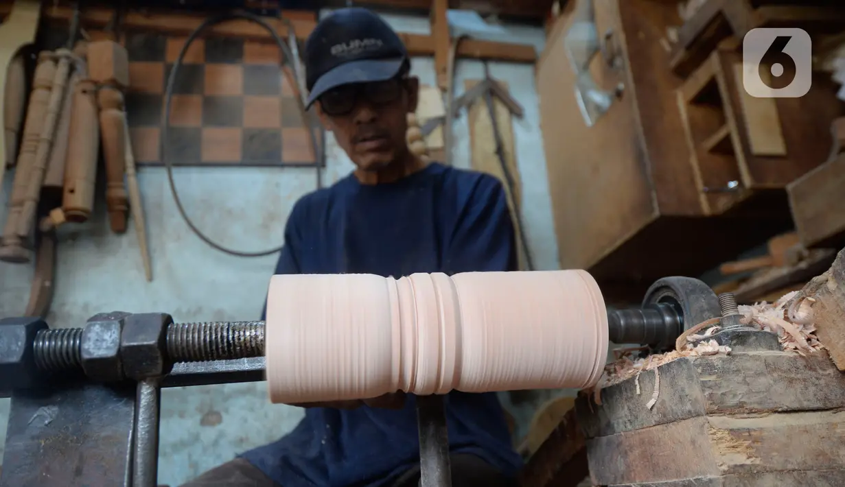 Pekerja sedang membubut kayu untuk kaki kursi/sofa pesanan pelanggan di Kedaung, Tangerang Selatan, Banten, Jumat (6/11/2020). Pemesanan kursi/sofa kini perlahan-lahan mulai normal dibandingkan pada awal pandemi COVID-19. (merdeka.com/Dwi Narwoko)