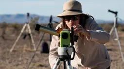 Seorang wanita menggunakan alat khusus bersiap untuk melihat gerhana matahari annular di Estancia El Muster, Argentina (26/2). Para astronom dan penyuka astronomi di Argentina berkumpul untuk menyaksikan gerhana matahari annular. (AFP/Alejandro Pagni)