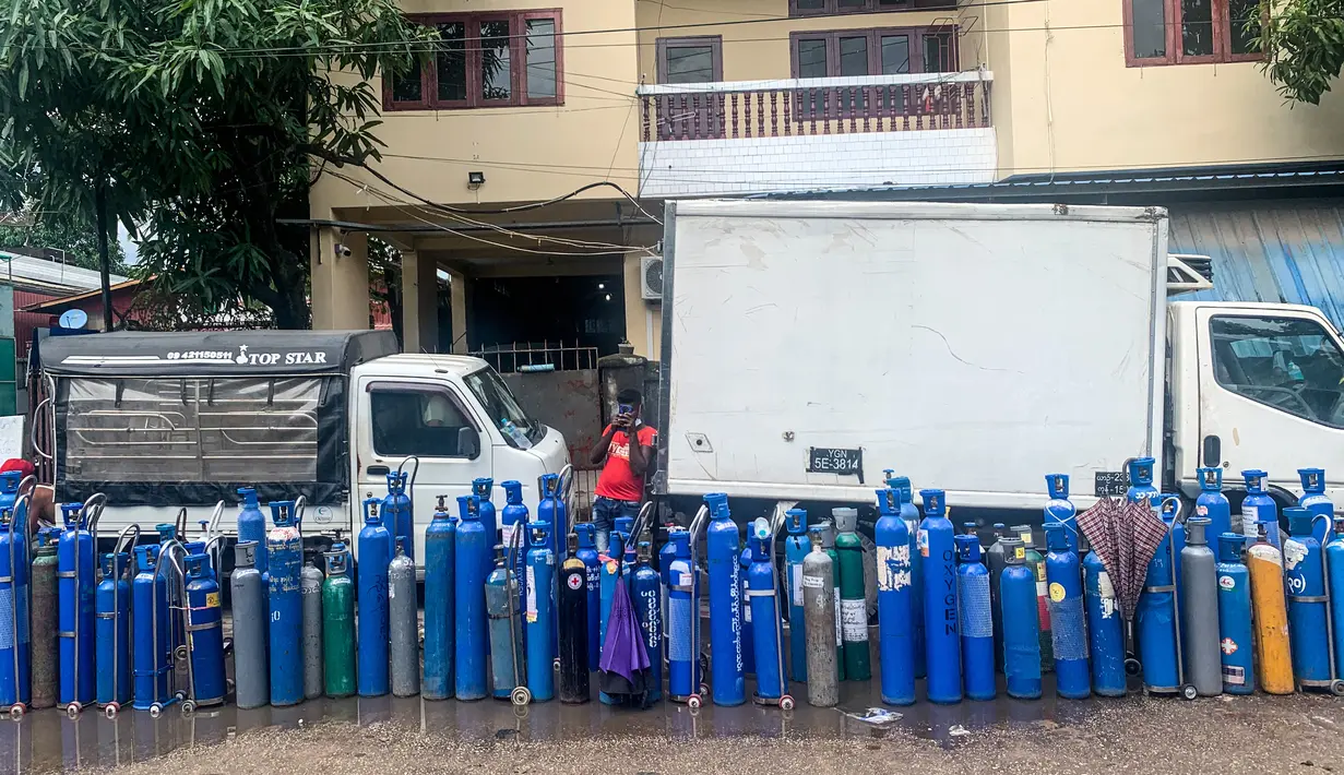 Tabung oksigen kosong tampak dalam barisan ketika orang-orang menunggu untuk mengisinya di luar sebuah pabrik di Yangon, Myanmar, Minggu (11/7/2021). Para pejabat mengatakan Myanmar mengalami lonjakan kasus COVID-19, memicu kelangkaan pasokan oksigen yang sangat dibutuhkan pasien. (Ye Aung THU/AFP)