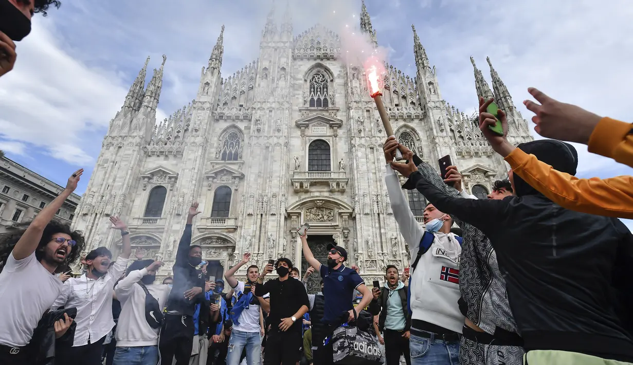 Para pendukung dan fans Inter Milan menyalakan flare dan meneriakkan yel-yel di depan katedral gothic di kawasan Piazza Duomo, Milan, Minggu (2/5/2021) merayakan kepastian Inter Milan merebut gelar juara Scudetto Liga Italia 2020/2021. (LaPresse via AP/Claudio Furlan)