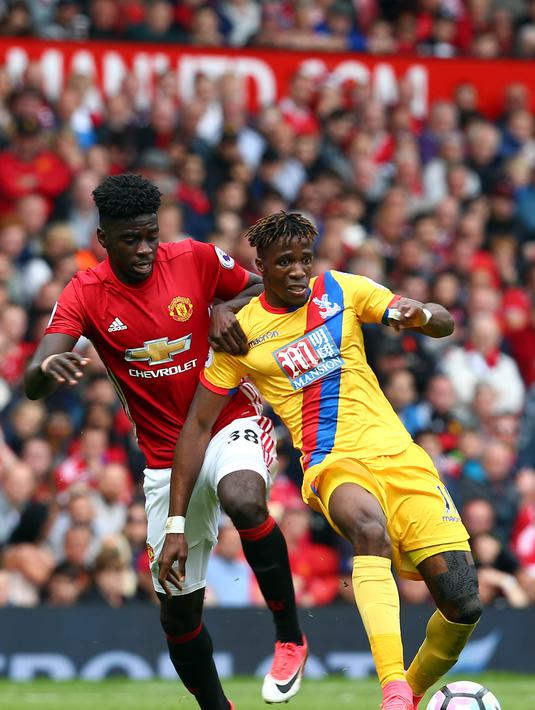 Gelandang Manchester United, Alex Tuanzebe, berebut bola dengan striker Crystal Palace, Wilfried Zaha, pada laga Premier League di Stadion Old Trafford, Inggris, Minggu (21/5/2017). MU menang 2-0 atas Palace. (EPA/Tim Keeton)