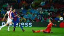 Pemain Barcelona, Luis Suarez menendang bola yang berusaha dihadang kiper Olympiakos, Silvio Proto dalam fase grup Liga Champions di Camp Nou, Kamis (19/10). Barca menang 3-1 pada laga yang diwarnai kartu merah terhadap Gerard Pique.  (AP/Manu Fernandez)