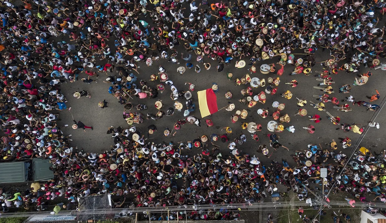 Orang-orang mengambil bagian dalam perayaan Hari Suci Tak Bersalah di Caucagua, Venezuela, Selasa (28/12/2021). Warga merayakan variasi hari raya itu dengan mengenakan pakaian tua, mengecat wajah mereka hitam dan lidah merah. (AP Photo/Matias Delacroix)