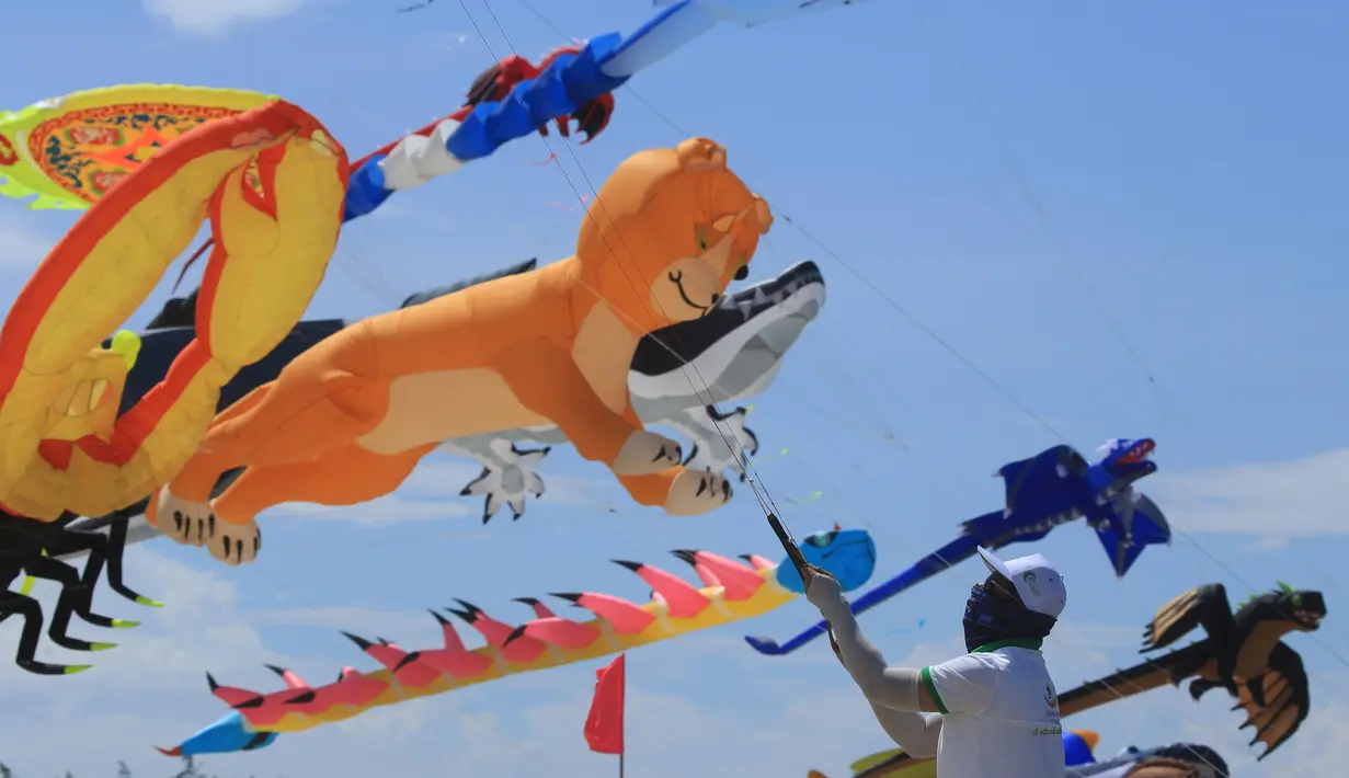 Seorang peserta menerbangkan layang-layangnya diatas pantai Tam Thanh selama Festival Internasional Kite di Quang Nam, Vietnam (11/6). Dalam festival ini, pengrajin menunjukan keterampilan membuat, serta menerbangkan layang-layangnya. (AP Photo/Hau Dinh)