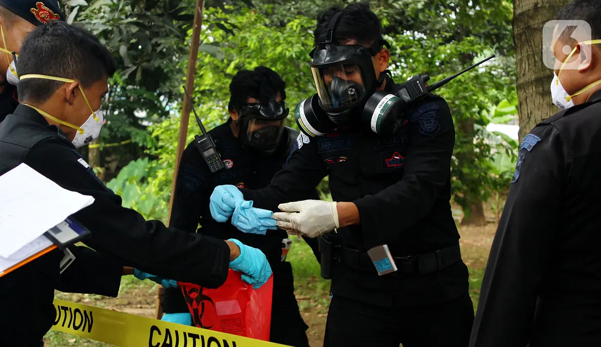 Tim Kimia Biologi dan Radioaktif (KBR) Gegana Polri seusai mengambil sampel tanah yang terpapar radioaktif di Perumahan Batan Indah, Tangerang Selatan, Sabtu (15/2/2020). Sebuah area tanah kosong di Perumahan Batan Indah, terpapar radioaktif jenis Cesium-137. (merdeka.com/Magang/Muhammad Fayyadh)