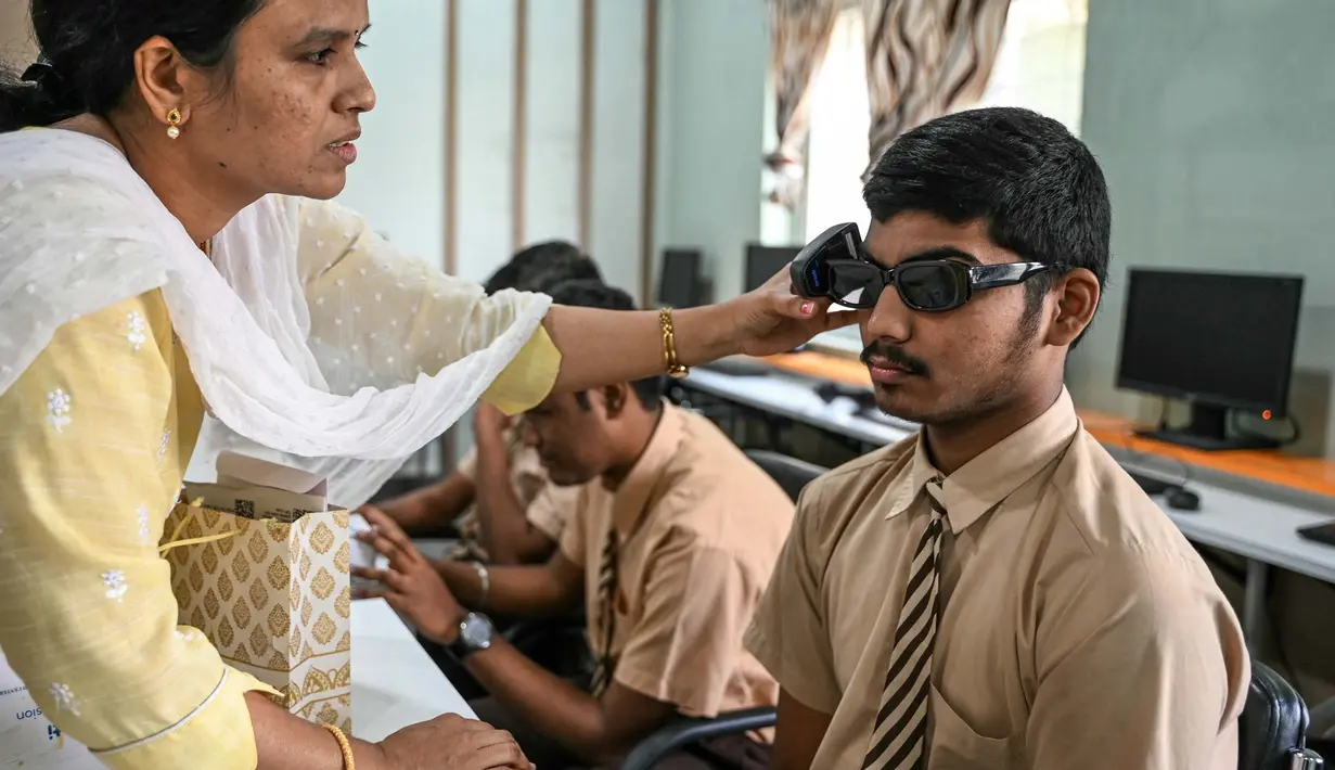 Sebuah sekolah tunanetra di Hyderabad, India menggelar program pelatihan pengenalan sekaligus penggunaan kacamata pintar berteknologi Artificial intelligence (AI) untuk para siswa disabilitas netra. (NOAH SEELAM/AFP)