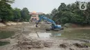 Petugas Sudin Sumber Daya Air (SDA) menggunakan alat berat untuk mengeruk lumpur yang mengendap di Setu Mangga Bolong, Jagakarsa, Jakarta, Rabu (2/9/2020). Pengerukan untuk meningkatkan fungsi setu sebagai tangkapan air, pengendali banjir dan penambahan daya tampung. (Liputan6.com/Immanuel Antonius)