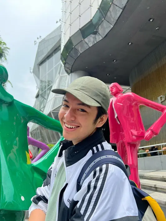 Pemeran film Ratu Ilmu Hitam itu melengkapi penampilannya dengan baseball cap warna merah dan sneakers monokrom. Sementara Angga tampil memadukan t-shirt tosca, jaket monokrom, dan celana cargo army.  (Instagram/shenacinnamon).