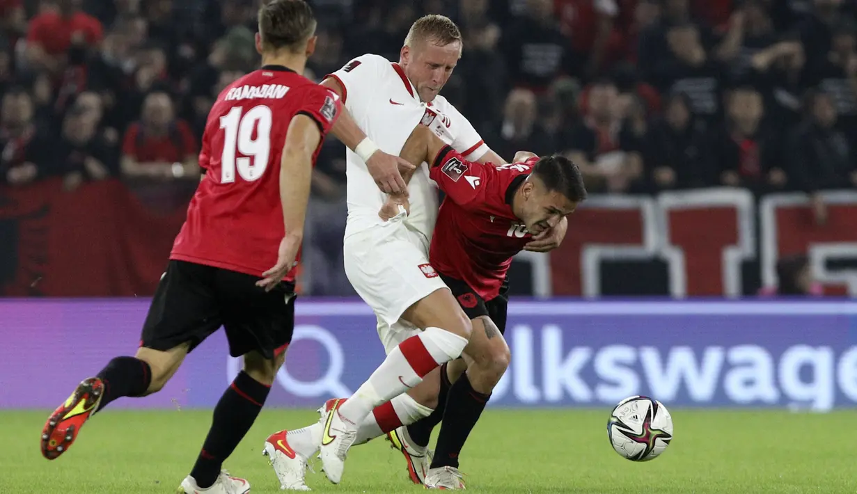Bek Polandia Kamil Glik dan penyerang Albania Rey Manaj berebut bola pada lanjutan Grup I Kualifikasi Piala Dunia 2022 Zona Eropa, di Air Albania Stadium, Rabu (13/10/2021) dini hari WIB.  Kemenangan Polandia 1-0 atas Albania diwarnai aksi pelemparan botol oleh suporter. (AP Photo/Franc Zhurda)