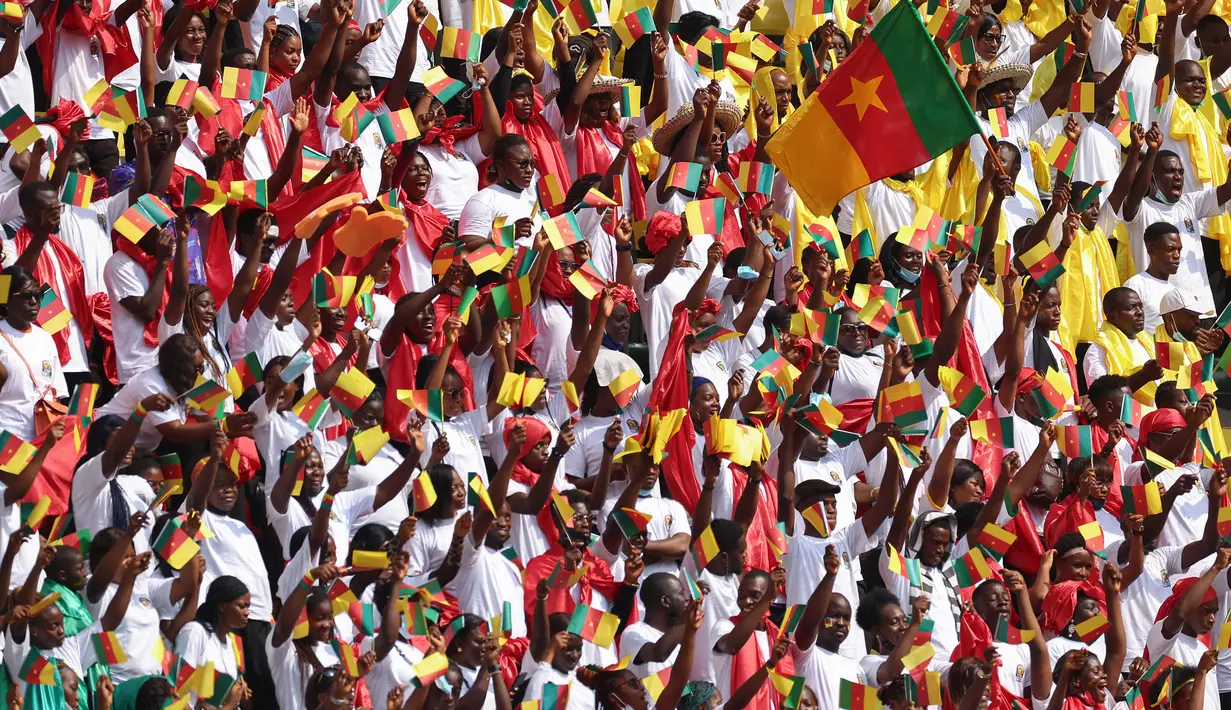 Suporter Kamerun bersorak saat upacara pembukaan turnamen sepak bola Piala Afrika (CAN) 2021 di Stade d'Olembé di Yaounde (9/1/2022). Laga pembuka Piala Afrika 2021 dimulai dengan pertandingan Kamerun vs Burkina Faso.  (AFP/Kenzo Tribouillard)