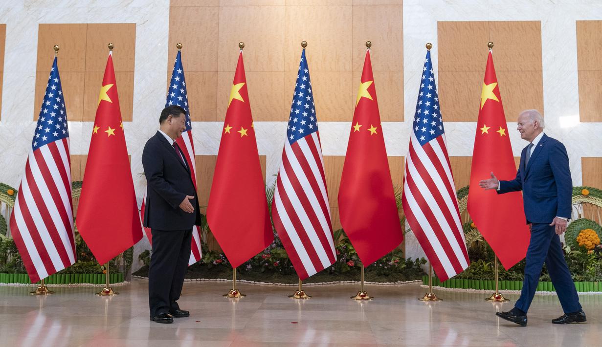 Presiden AS Joe Biden berjalan untuk menyambut Presiden China Xi Jinping sebelum pertemuan di sela-sela KTT G20 di Nusa Dua, di Bali, Senin (14/11/2022). Pertemuan kedua Presiden tersebut akhirnya terwujud di Bali. Suasana pertemuan bersejarah itu tampak hangat. (AP/Alex Brandon)