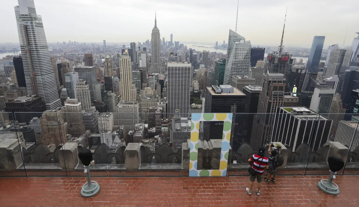 Para pengunjung menikmati pemandangan kota dari anjungan pengamatan Top of the Rock di New York, Amerika Serikat, Kamis (6/8/2020). Top of the Rock kembali dibuka untuk umum setelah ditutup sementara pada Maret lalu untuk membantu membatasi penyebaran COVID-19. (Xinhua/Wang Ying)