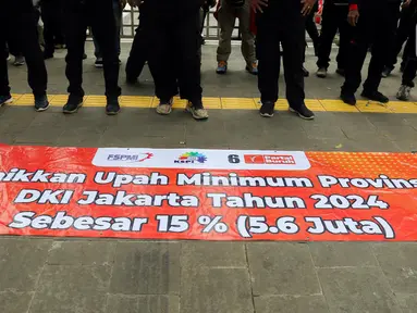 Sejumlah massa simpatisan Partai Buruh dan beberapa serikat buruh membentangkan spanduk saat melakukan demo di depan Balai Kota DKI Jakarta, Selasa (28/11/2023). Mereka meminta kenaikan Upah Minimum Provinsi (UMP) 2024 sebesar 15 persen. (Liputan6.com/Herman Zakharia)