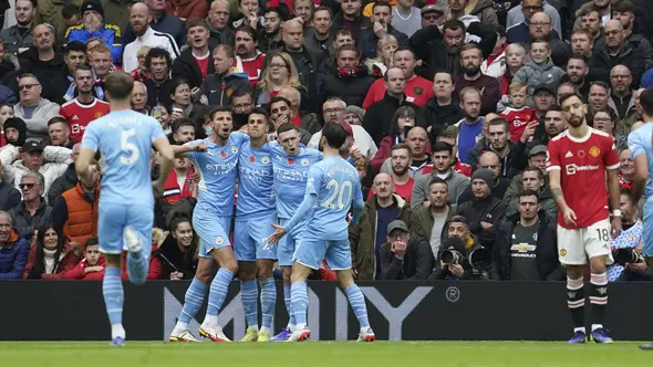 Pemain Manchester City merayakan gol bunuh diri bek Manchester United (MU) Eric Bailly pada laga Liga Inggris di Old Trafford, Sabtu (6/11/2021). (AP Photo/Jon Super)