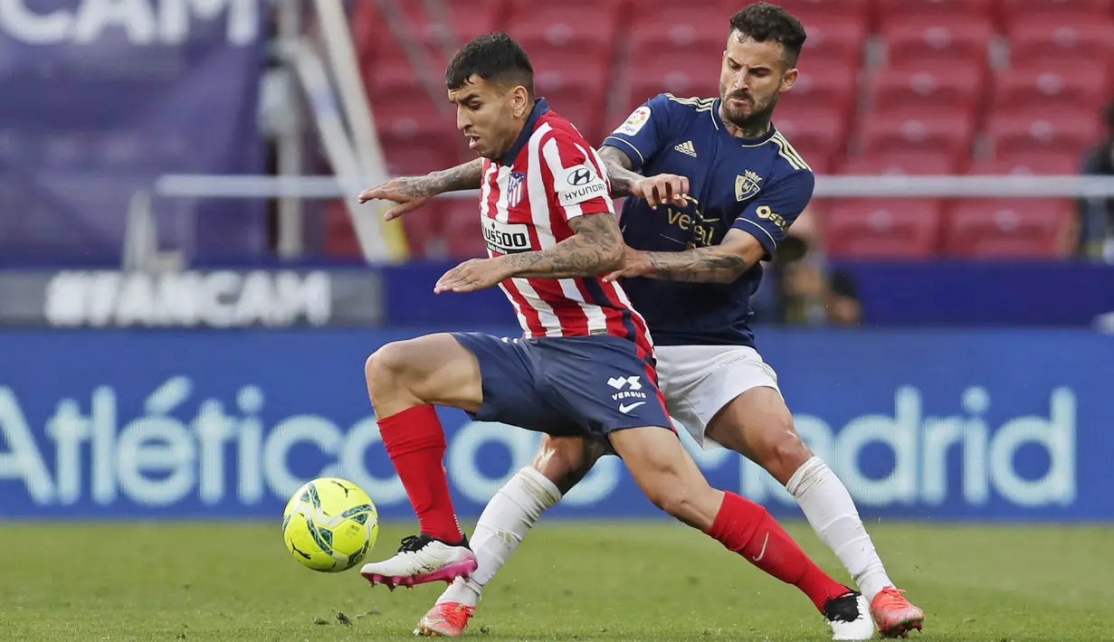 Pemain Atletico Madrid, Angel Correa, berusaha melewati pemain Osasuna, Ruben Garcia, pada laga Liga Spanyol di Stadion Wanda Metropolitano, Minggu (16/5/2021). Atletico Madrid menang dengan skor 2-1. (AP/Manu Fernandez)