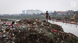 Anak- anak mengenakan pakaian usai mencari biawak di tepi Sungai Banjir Kanal Barat, Petamburan, Jakarta, Jumat (9/11). Mereka memanfaatkan waktu bermain usai pulang sekolah. (Liputan6.com/Fery Pradolo)