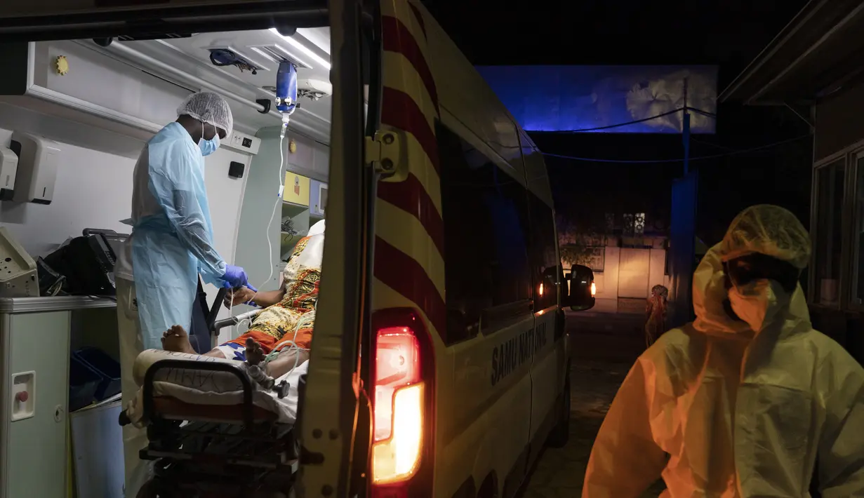 Dokter Mobile Emergency Care Service (SAMU) Yahya Niane (kiri) membantu Binta Ba, yang hamil delapan bulan dan terinfeksi COVID-19, untuk dipindahkan menuju rumah sakit di Dakar, Senegal, pada 5 Agustus 2021. Longsoran kasus datang saat Senegal menghadapi gelombang ketiga dengan kedatangan varian de