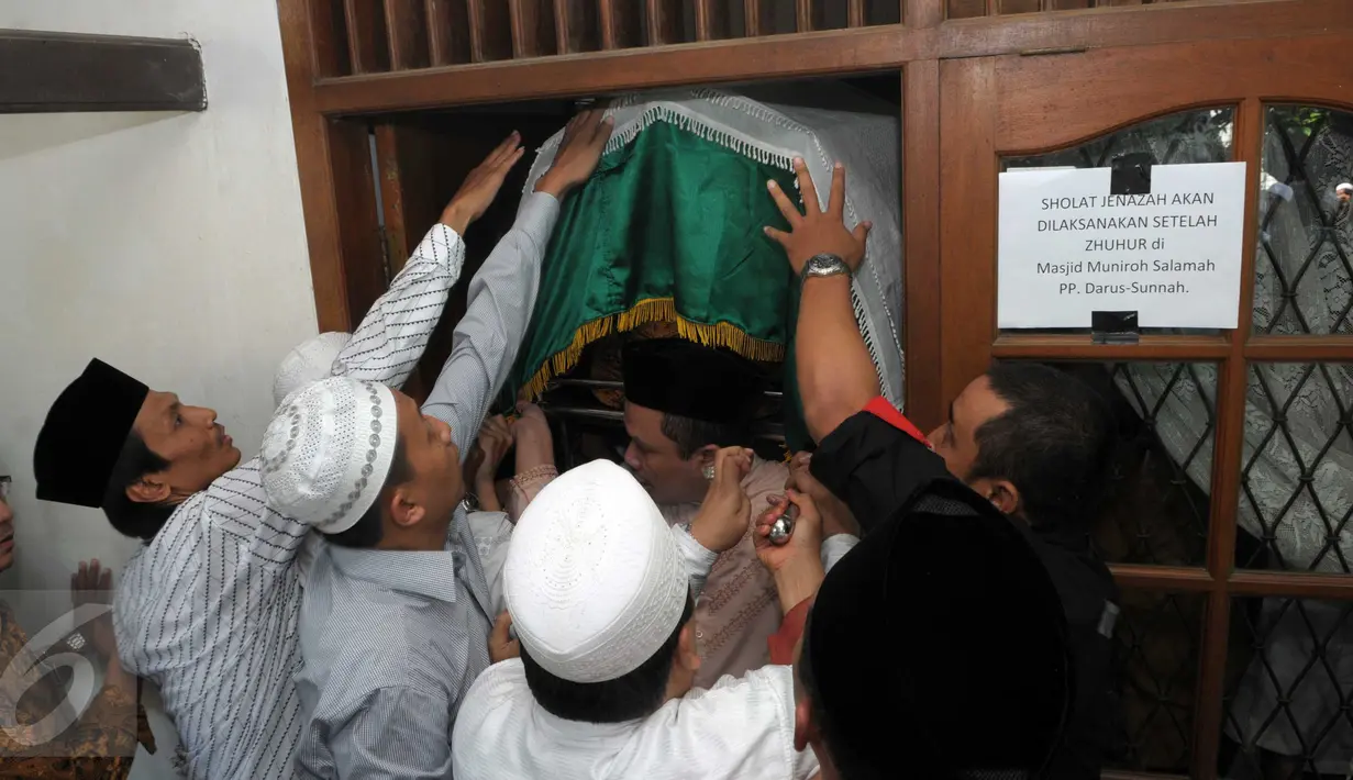 Sejumlah orang saat memasukkan keranda jenazah Ali Mustafa Yaqub  ke rumah duka di Pisangan Barat, Ciputat, Tangsel, Kamis (28/4). Mantan Imam Masjid Istiqlal itu wafat di usia 64 tahun karena sakit. (Liputan6.com/Helmi Afandi)