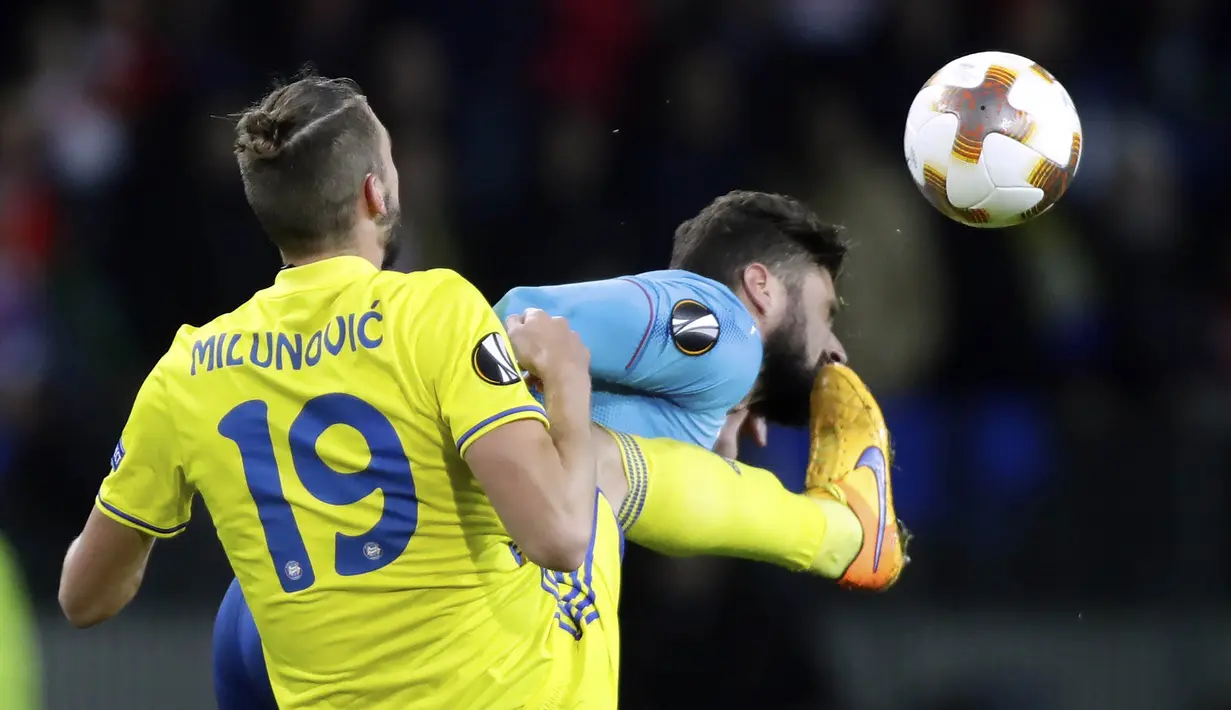 Bek BATE Borisov, Nemanja Milunovic, menendang striker Arsenal, Olivier Giroud, pada laga Liga Europa di Stadion Borisov, Kamis (28/9/2017). Arsenal menang 4-2 atas BATE Borisov. (AP/Sergei Grits)
