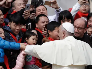 Paus Fransiskus bersalaman dengan jemaat dari China saat audiensi umum mingguan di Lapangan Santo Petrus, di Vatikan (18/4). (AP/Gregorio Borgia)