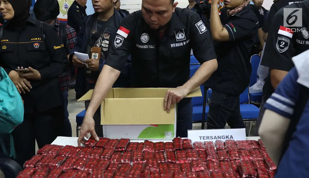 Petugas merapihkan barang bukti kasus narkoba di Gedung Kantor Pos Pasar Baru, Jakarta, Senin (10/9). Barang bukti berupa 719,8 gram methampethamine, 50ribu butir ekstasi, 4 kg daun khat, 4 kg ketamine. (Liputan6.com/Immanuel Antonius)